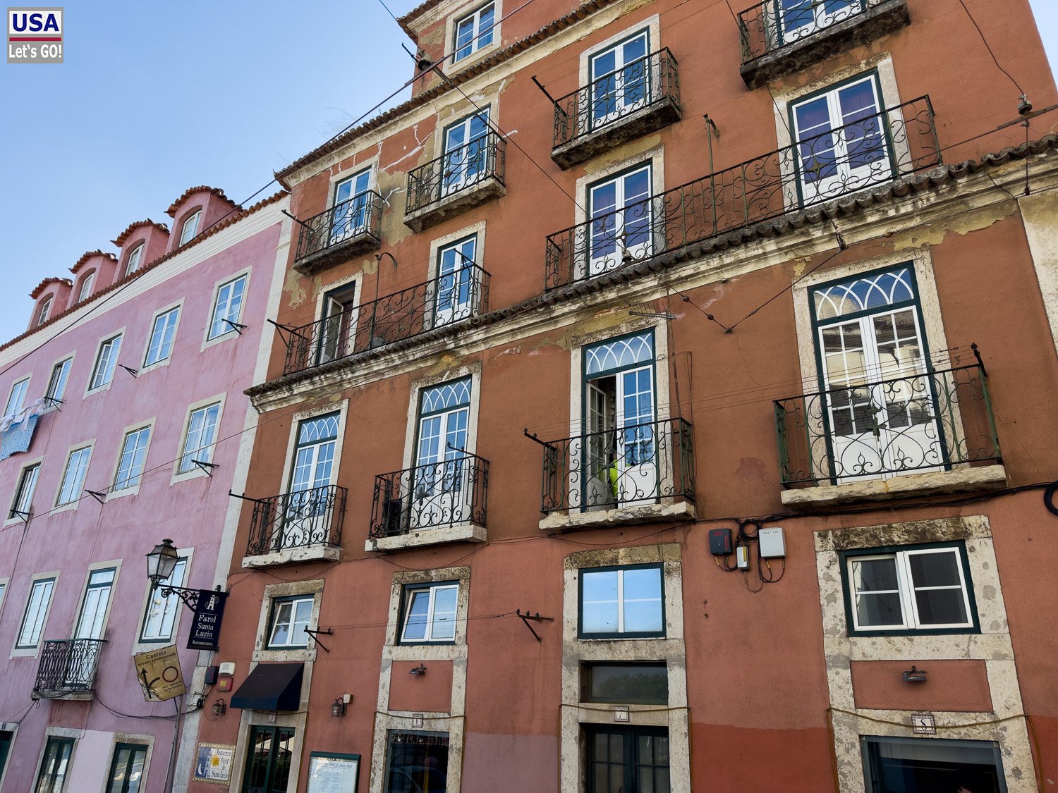 Rote Altbaufassade mit Balkonen in Lissabon