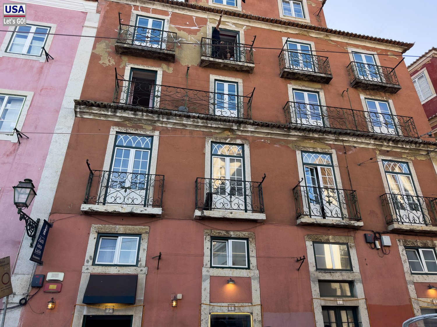 Rotbraune Altbaufassade mit schmiedeeisernen Balkonen in Lissabon