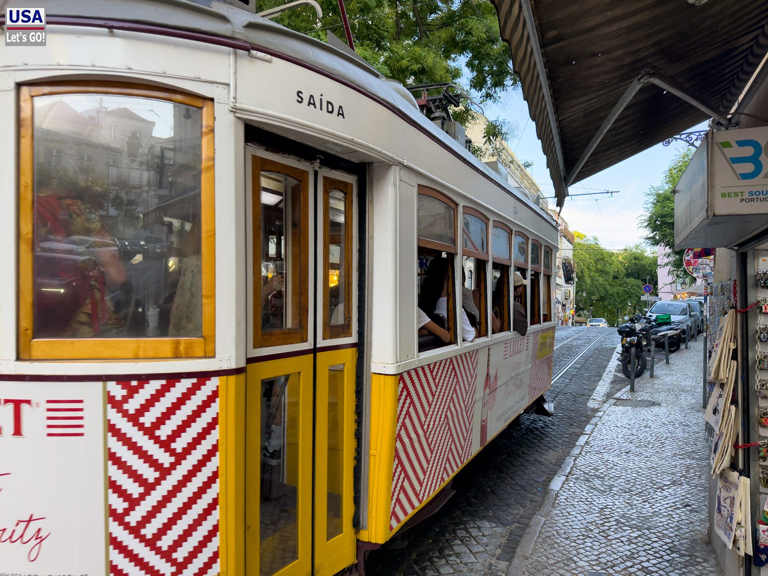 Historische gelbe Straßenbahn in einer Gasse der Alfama
