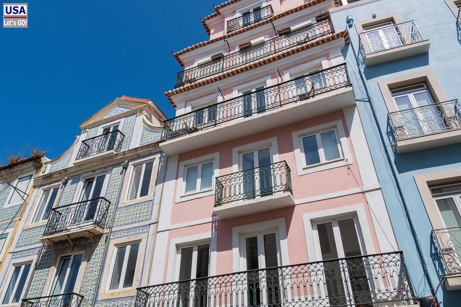 Rosafarbene Altbaufassade mit Balkonen in Lissabon