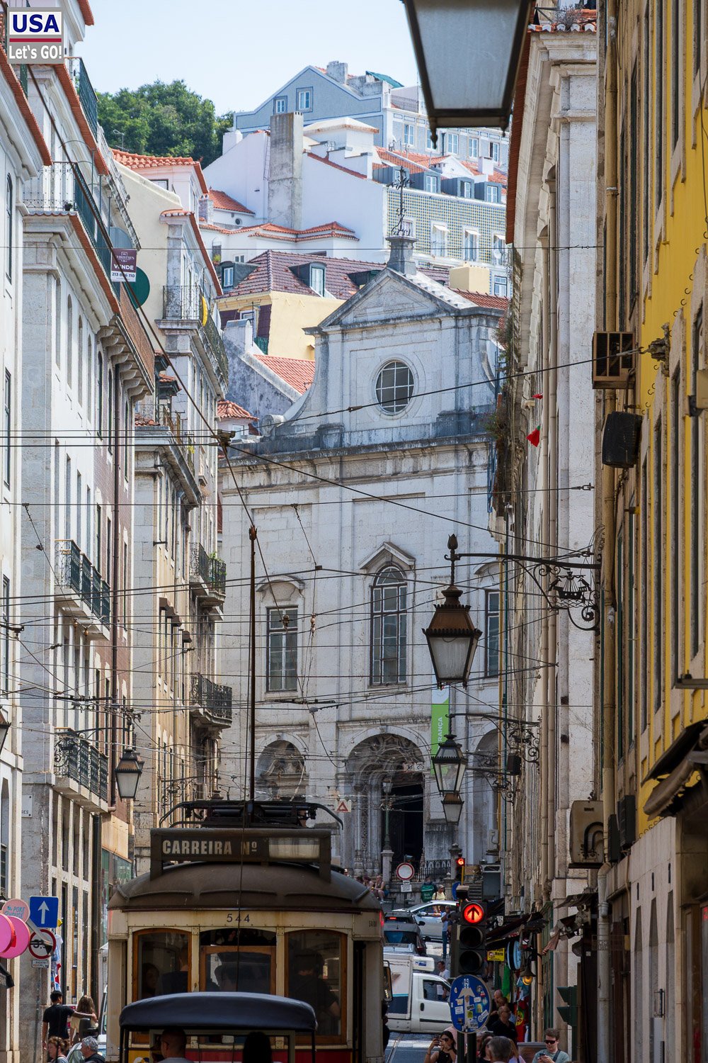 Straßenbahn in einer Querstraße der Baixa vor einer Kirche