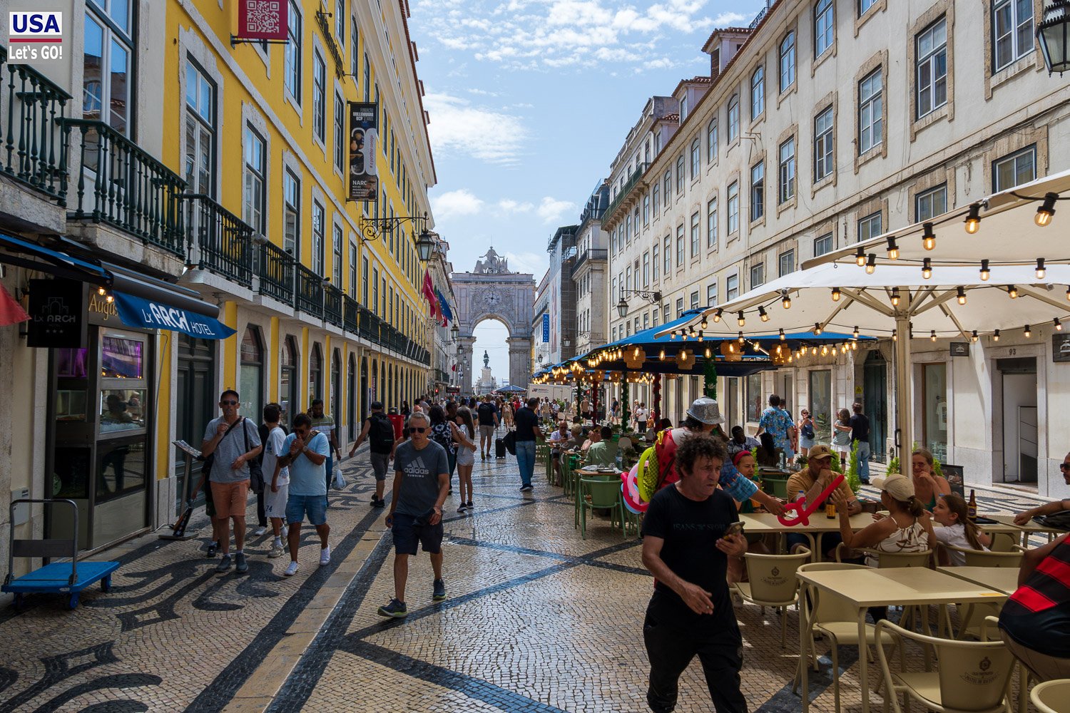 Rua Augusta mit Sonnenschirmen und dem Triumphbogen im Hintergrund
