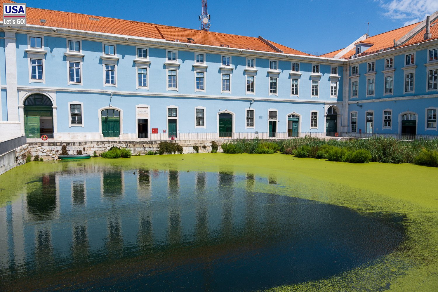 Blaues Palastgebäude, das sich in einem Teich spiegelt, am Weg Richtung Belém