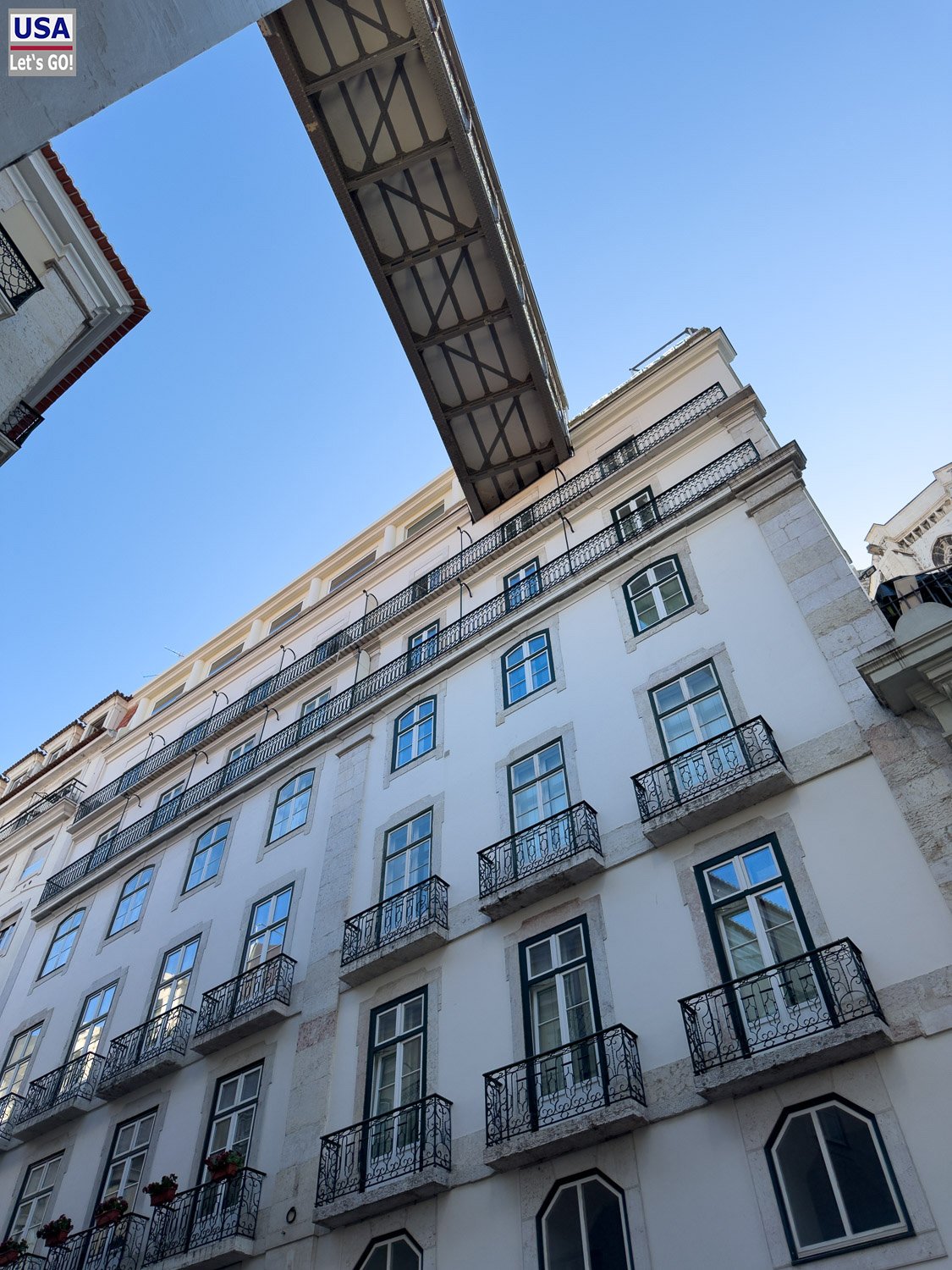 Weißes Gebäude mit Balkonen in der Baixa von unten