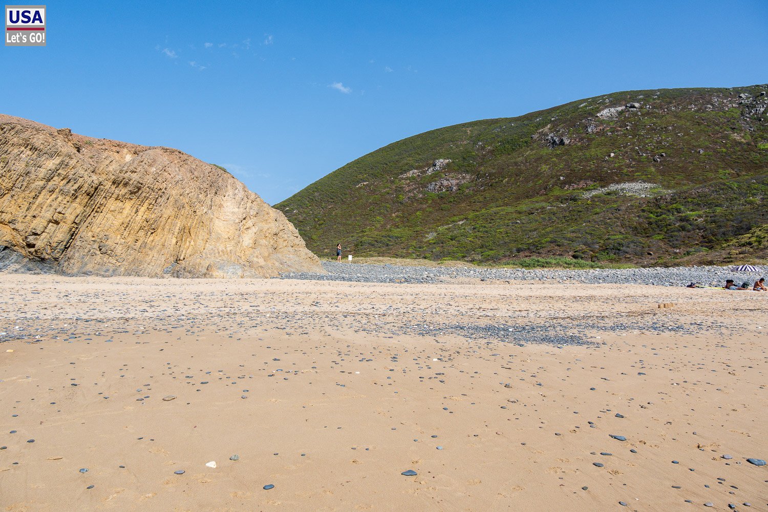 Einsame Praia de Vale Figueira zwischen grünen Hängen