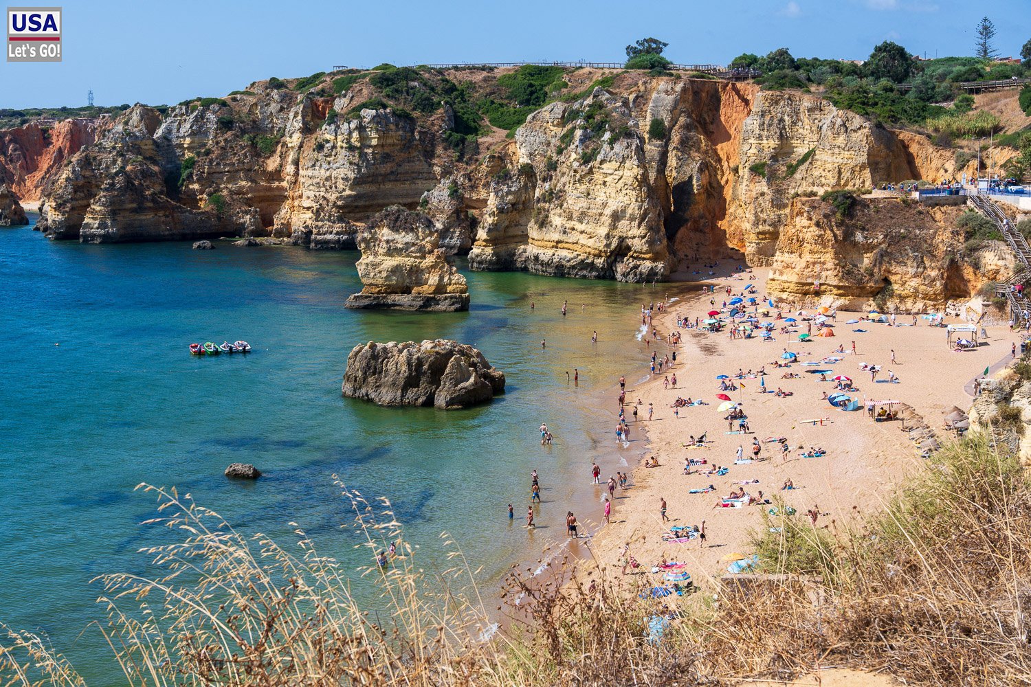 Badegäste an der Praia de Dona Ana zwischen den Felsen