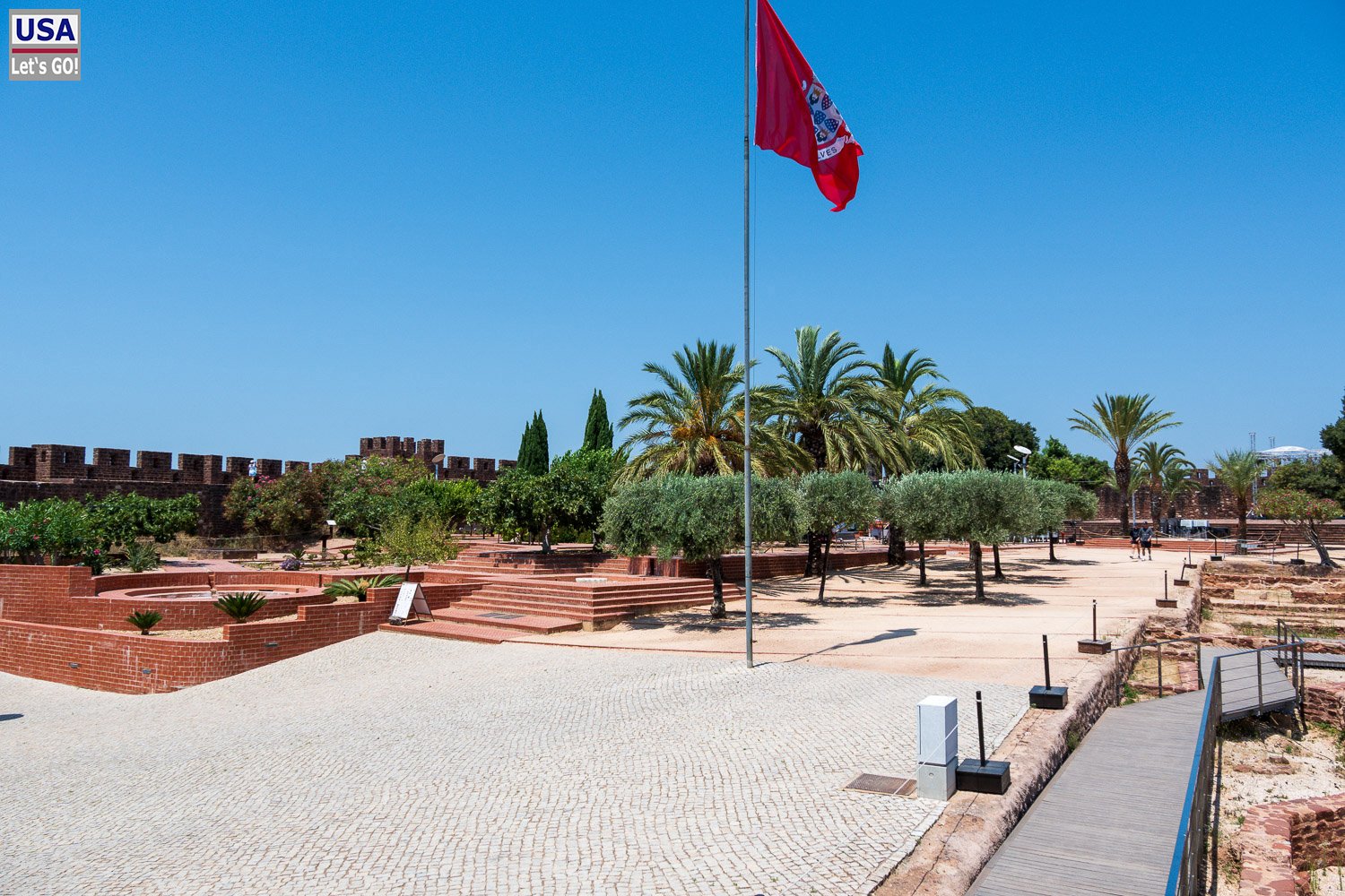 Burghof von Silves mit Palmen und Fahne