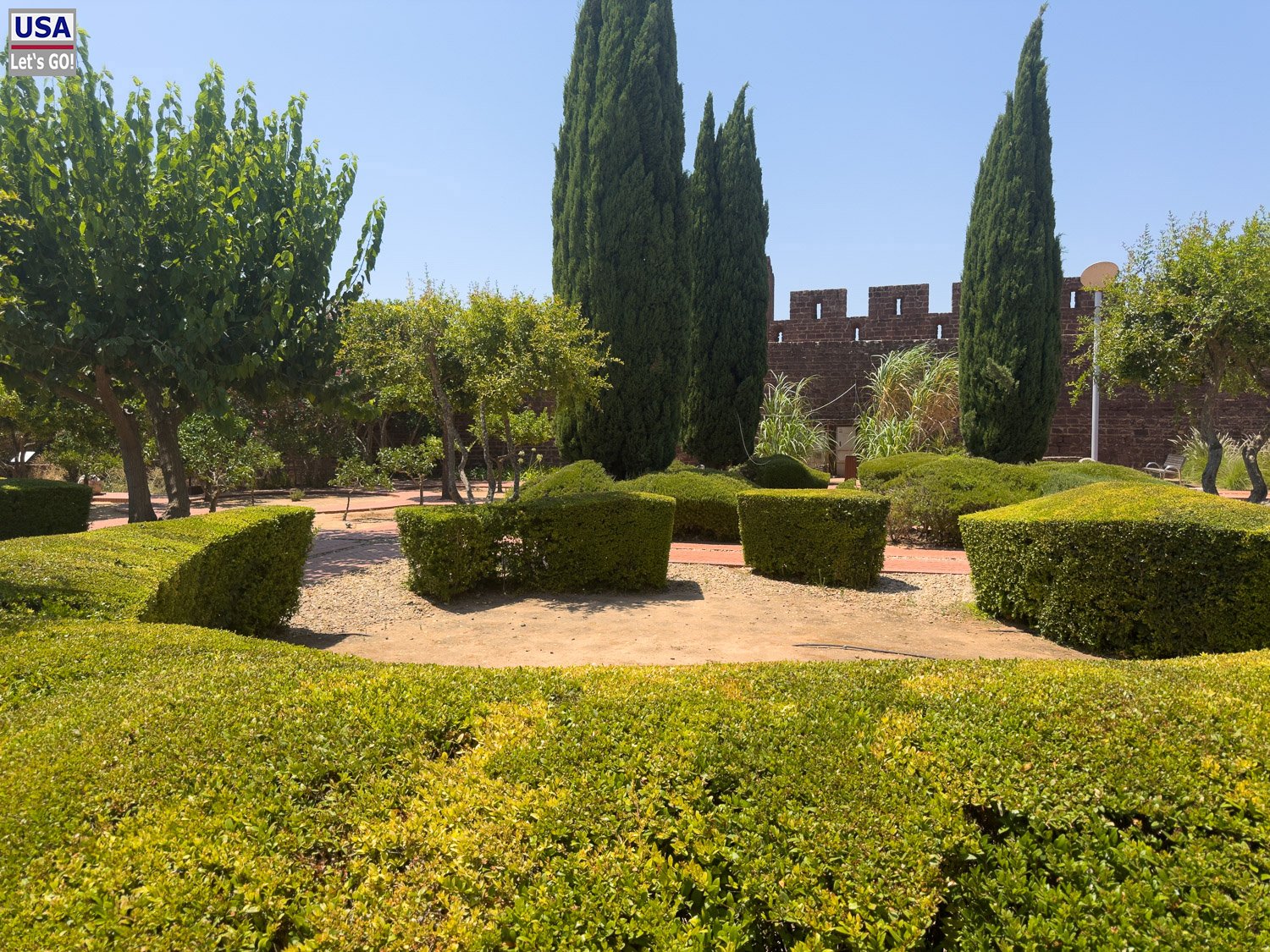Gepflegter Garten mit Hecken und Zypressen im Castelo