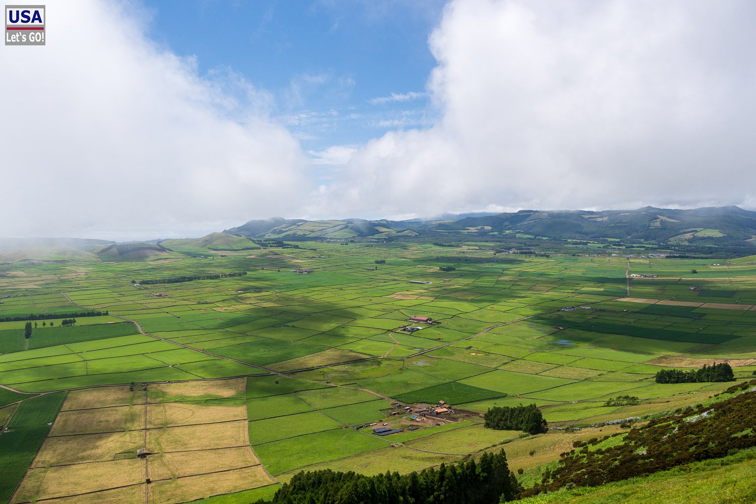 Felder und Steinmauern auf Terceira bei aufreißenden Wolken
