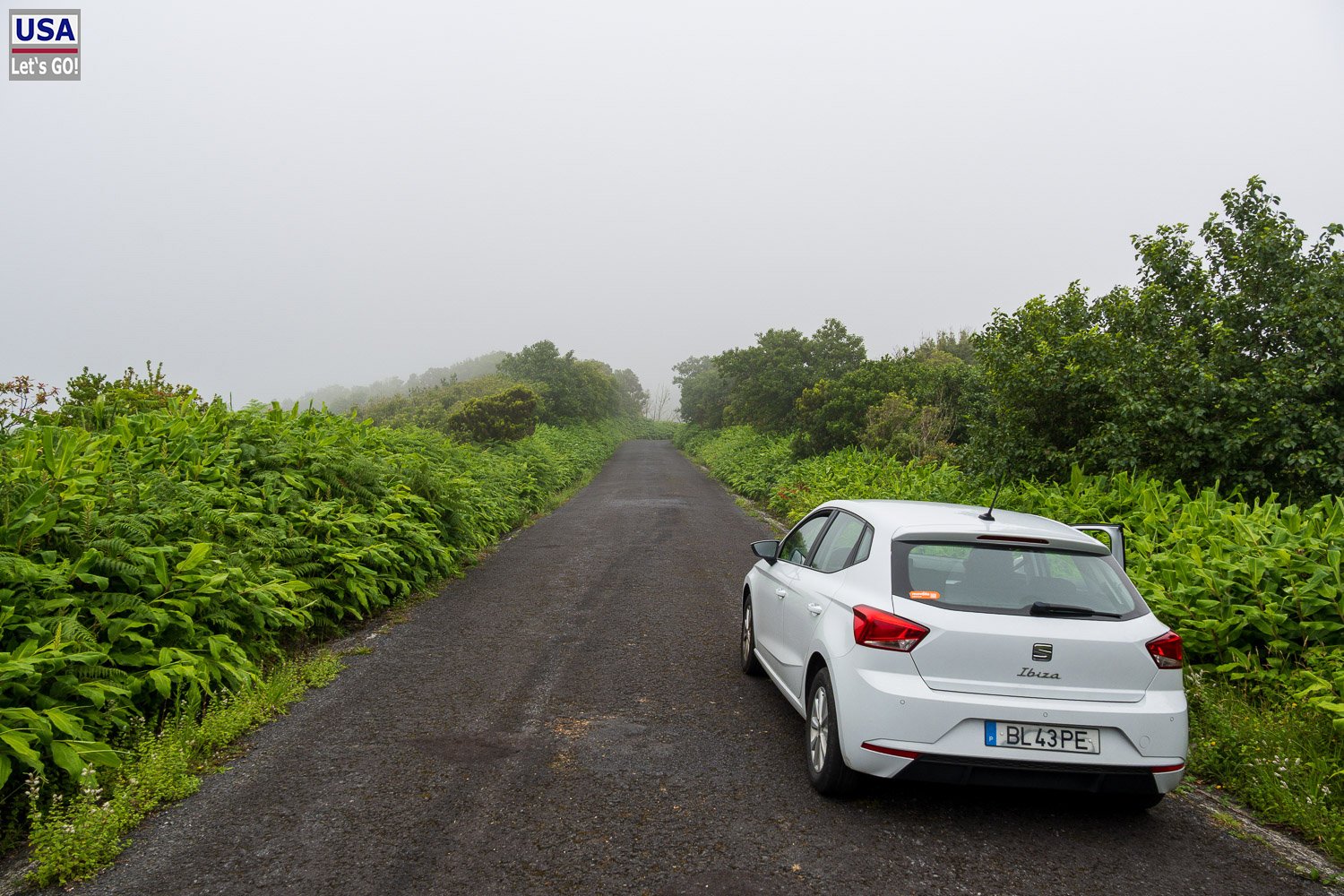 Mietwagen auf einer Bergstraße im Nebel