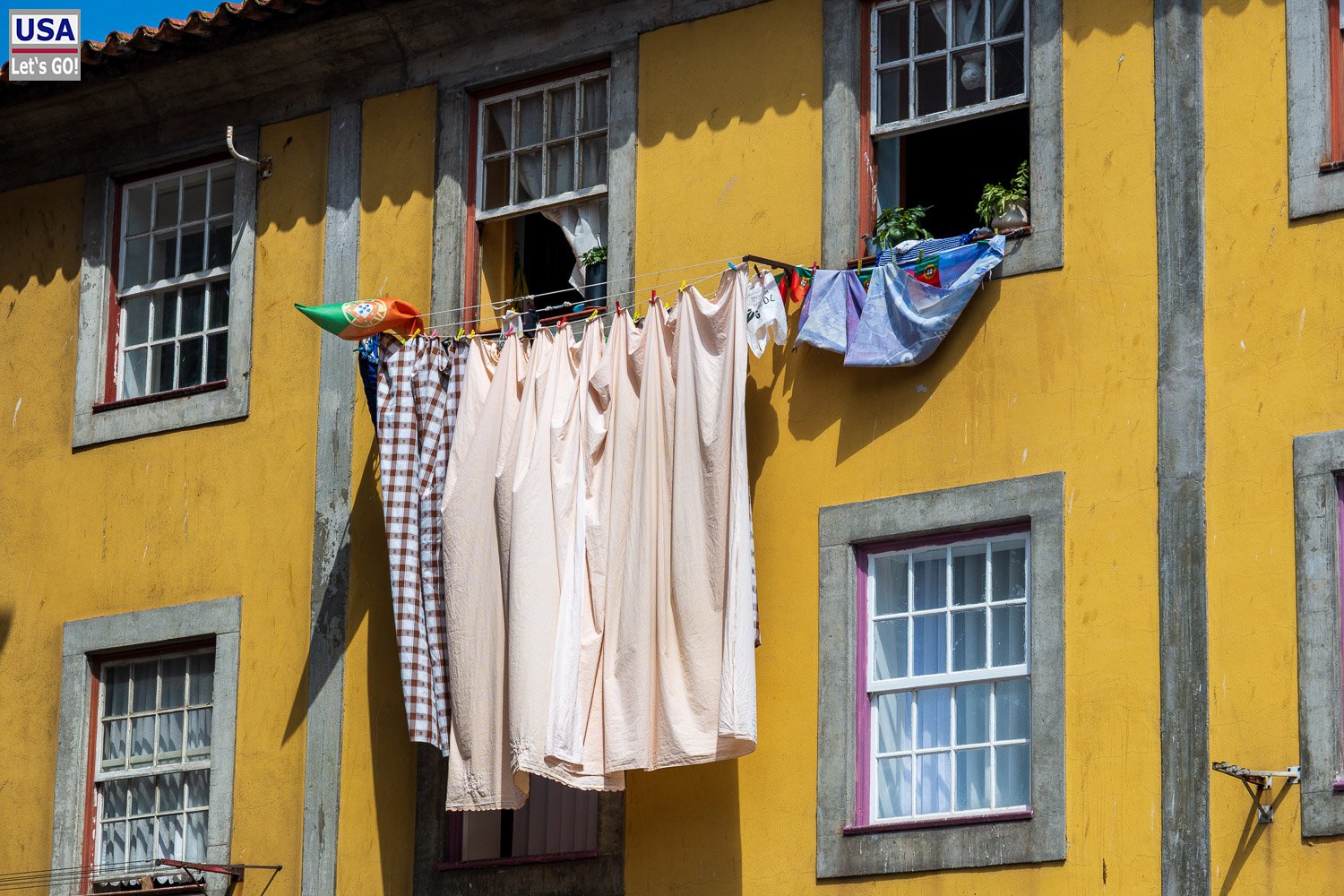 Gelbes Haus mit Wäsche vor dem Fenster